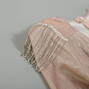 Detail of champagne gold metallic fabric with sparkling rhinestone fringe on shoulder