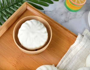 Realistic 8cm white steam bun squeeze toy with detailed texture on a mini steamer base