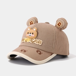 Detailed close-up of corduroy texture and cartoon bear patch on toddler baseball cap