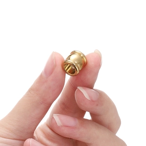 Gold stainless steel cylindrical spacer beads for DIY jewelry making shown on fingers