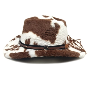 Détail d'un chapeau de cowboy en fausse fourrure à motif vache avec ceinture et boucle