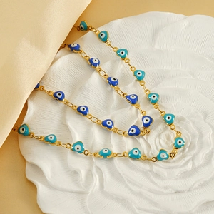 Golden heart-shaped Turkish evil eye bracelet on an elegant white floral display tray