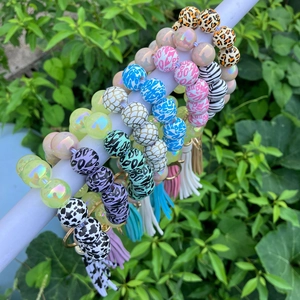 Detailed view of leopard and cow print silicone bead bracelets with matching tassels