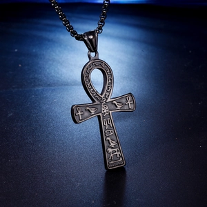 Close-up of black Ankh cross pendant with ancient Egyptian hieroglyphics on dark chain