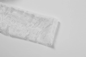 Close-up of white floral lace fabric detail with delicate mesh and intricate patterns
