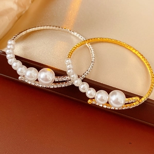 Detail shot of gold and silver elastic bracelets with pearls and sparkling rhinestones