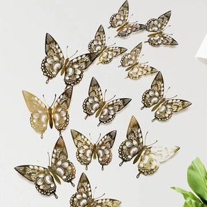 Detailed view of 12 hollow golden butterfly wall stickers in varying sizes on a white wall