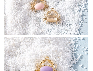 Macro shot of colorful crab-shaped alloy pendants with pink and purple enamel finish