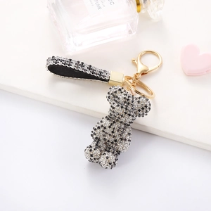 Macro detail of sparkling rhinestone bear keychain with gold clasp on white display