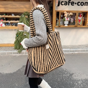 Gros plan du sac cabas en peluche à rayures jaunes et noires avec texture fausse fourrure