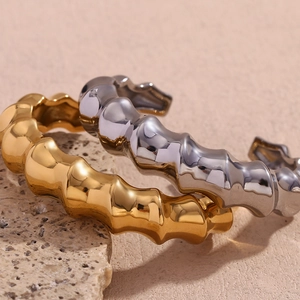 Detailed macro view of spiral bamboo style open cuff bracelets in gold and silver finish
