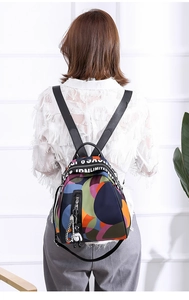 Detail of colorful oxford backpack featuring abstract patterns and cute bear pendant