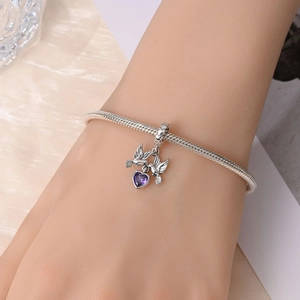 Dettaglio del bracciale a maglia snake in argento con due uccelli e zircone a cuore viola