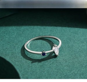 Detail of s925 silver ring featuring blue stone and marquise zircon on textured background