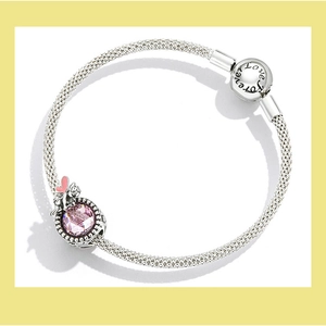 Detail of silver mesh bracelet featuring a pink crystal charm and Forever Love clasp