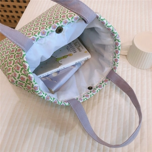 Detail view of floral canvas tote bag showing purple print and spacious interior capacity