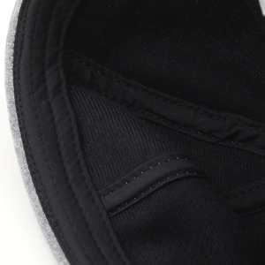 Detail shot of black cotton beanie showing inner sweatband and reinforced stitching