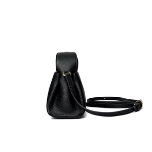 Side view of black pebble leather square handbag with adjustable strap and gold hardware