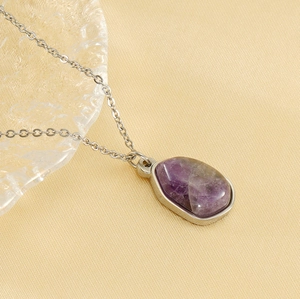 Close-up of irregular purple teardrop natural stone pendant on a silver O-chain necklace