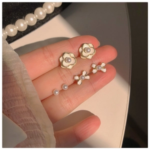 Close-up of elegant camellia, ribbon bow, and pearl earring set in vintage French style