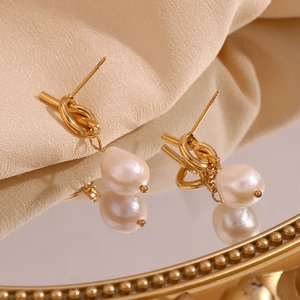 Detail of 18K gold knotted stud earrings with unique baroque freshwater pearls