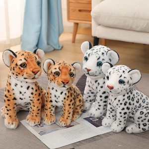 Close-up of four realistic snow leopard and leopard plush toys on a magazine