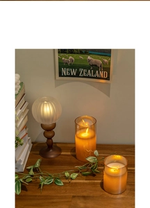 Macro shot of warm amber LED candles and vintage glass lamps on a rustic wooden table