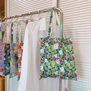 Detailed macro view of floral cotton tote bags hanging in a cozy home scene