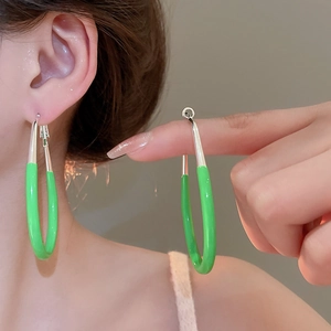 Detail of a long green hoop earring with silver metal links shown on a model