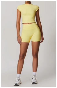 Detail of lemon yellow high-waist fitness shorts and cropped short sleeve yoga top set