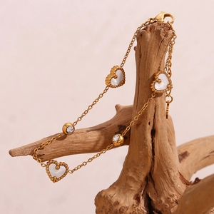 Detail of 18K gold plated bracelet with three shell hearts and round crystal accents