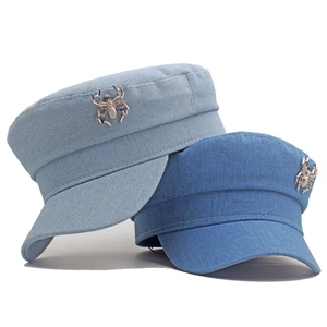 Détail de casquettes marin en denim bleu clair et moyen avec des broches araignée