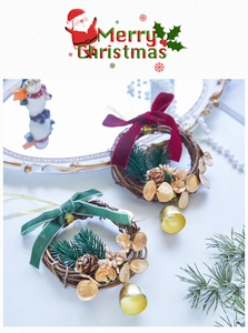 Close-up of mini Christmas wreath with pine cones, golden bells and velvet bows