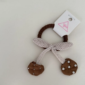 Brown hair scrunchie with white lace bow and beaded fabric charms on white background