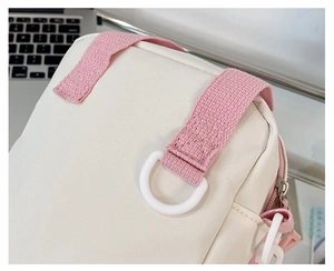 Detail of white canvas bag with pink strap, stitching craft, and D-ring attachment