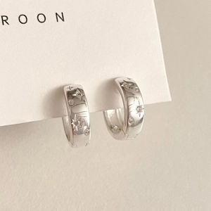Detailed close-up of sterling silver star earrings with delicate zircon stones