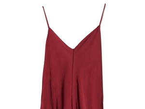 Detailed close-up of red satin dress with thin shoulder straps and V-neckline texture