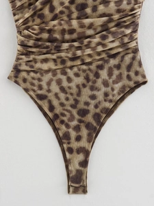 Detailed macro view of leopard print mesh bodysuit with elegant ruched texture and patterns
