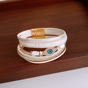 Detail of multi-layer white leather wrap bracelet with crystal evil eye and magnetic clasp