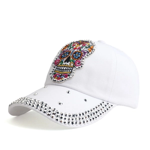 Detail of white cotton baseball cap featuring sugar skull embroidery and silver rhinestones