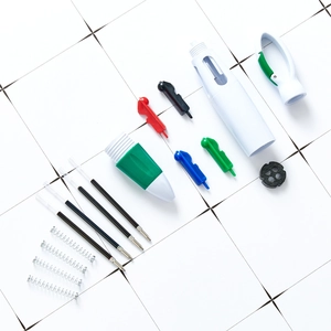 Disassembled 4-color carabiner ballpoint pen with ink refills, springs, and plastic body parts