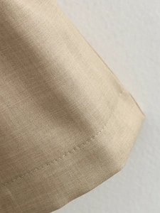 Macro view of khaki twill fabric texture and fine stitching detail on the dress