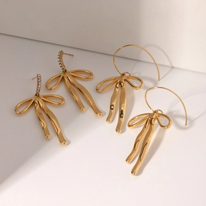 Close-up of polished 18k gold-plated bow earrings set with sparkling zircon crystals