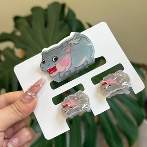 Detailed view of three cute acrylic hippo hair clips and pink flower hairpins for girls