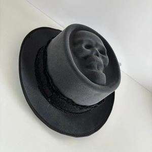 Detail of a 3D skull felt cowboy hat with double black metal chains and woven band
