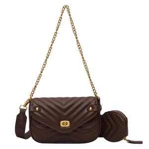 Detail of dark brown chevron quilted shoulder bag with gold chain and mini round pendant