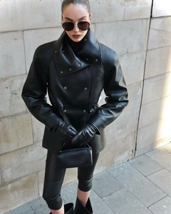 Détail d'une veste en similicuir à col montant avec cordon de serrage et design asymétrique
