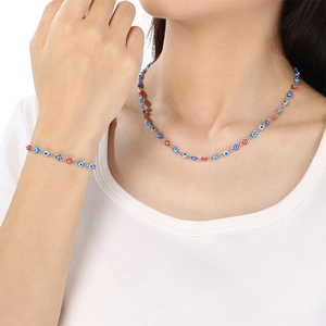 Detail of silver chain necklace and bracelet set with colorful evil eye beads on model