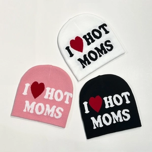 Close-up of knit beanies in white, pink, and black with I Love Hot Moms jacquard text
