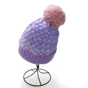 Detailed close-up of chunky knit purple beanie featuring a fluffy pink faux fur pom-pom